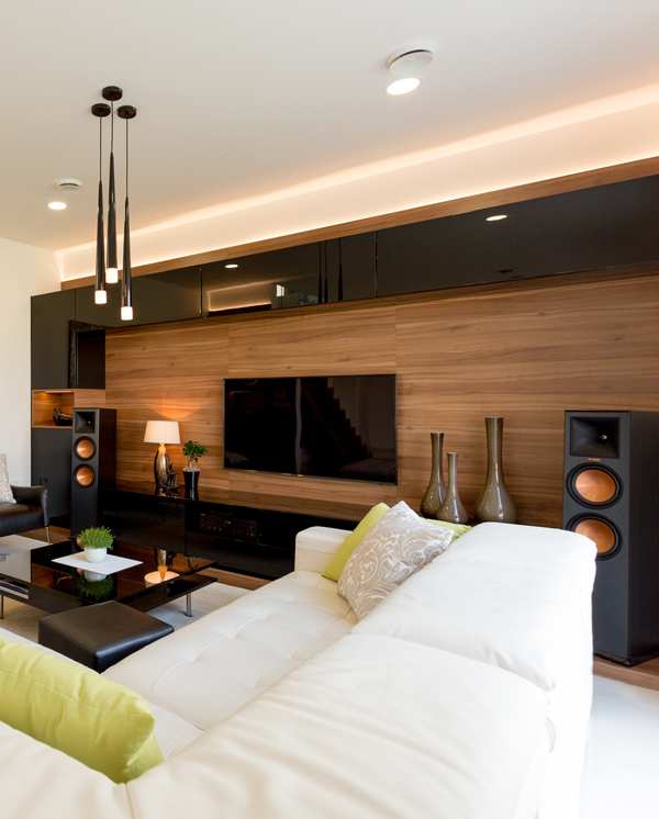 modern living room interior design with a white sectional sofa, wood accent wall, stylish decor, and a flat-screen TV