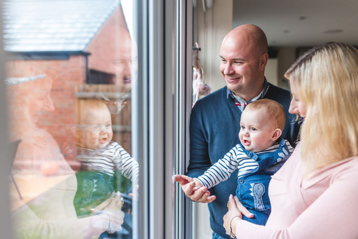 a family looking out of their window at home