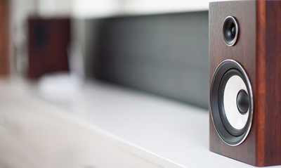 Wooden speakers on a white surface, showcasing quality audio design.