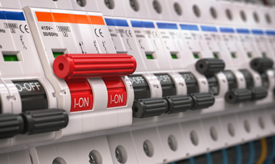 Close-up of electrical circuit breakers, featuring a red switch in the 'ON' position, with various other switches and indicators visible. Circuit safety devices are crucial for electrical safety.