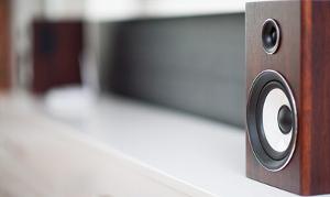 Close-up of a wooden speaker on a shelf, showcasing modern audio design, with a focus on sound quality for an enhanced listening experience.